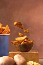 Golden crispy potato wedges in brown wooden bowl ready for serving to customers